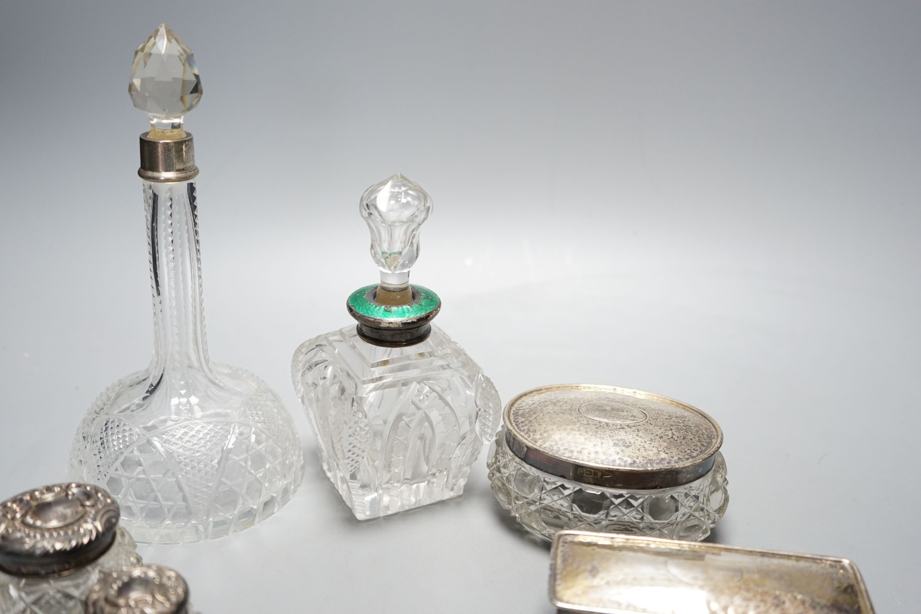 Two silver mounted cut glass scent bottles, including enamel(a.f.) and eight various dressing table items with silver lids.